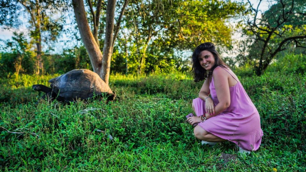 Tourist poses with giant tortoise in Santa Cruz Island.