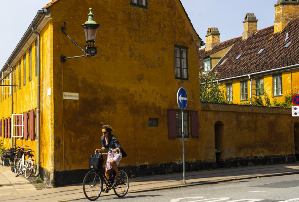 Woman riding a bike along Copenhagen's virbant neighborhood. Photo courtesy of Jeffrey Zhang.