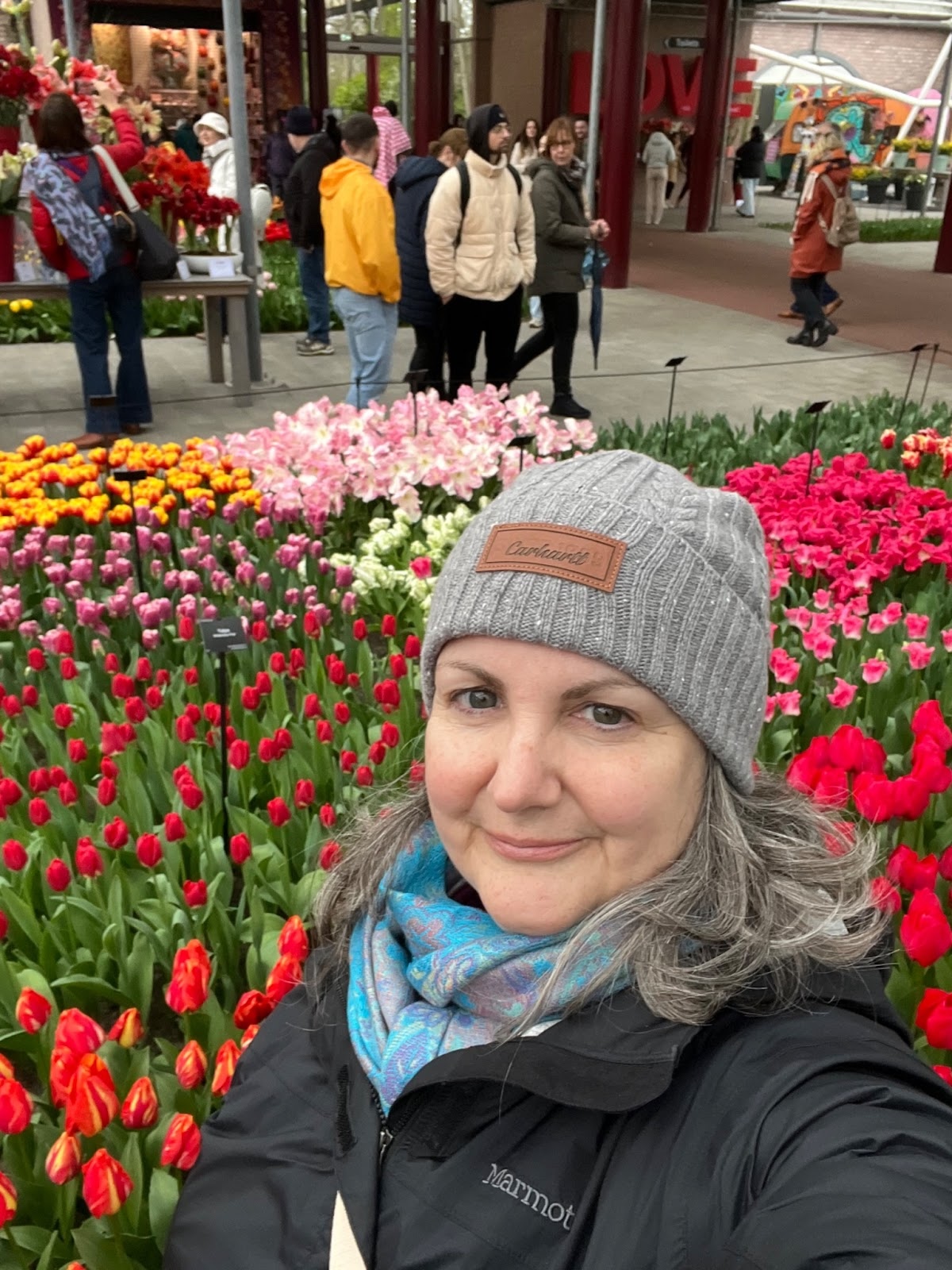 Michele standing among vibrant tulip displays at Keukenhof Gardens in the Netherlands during an AmaWaterways river cruise.